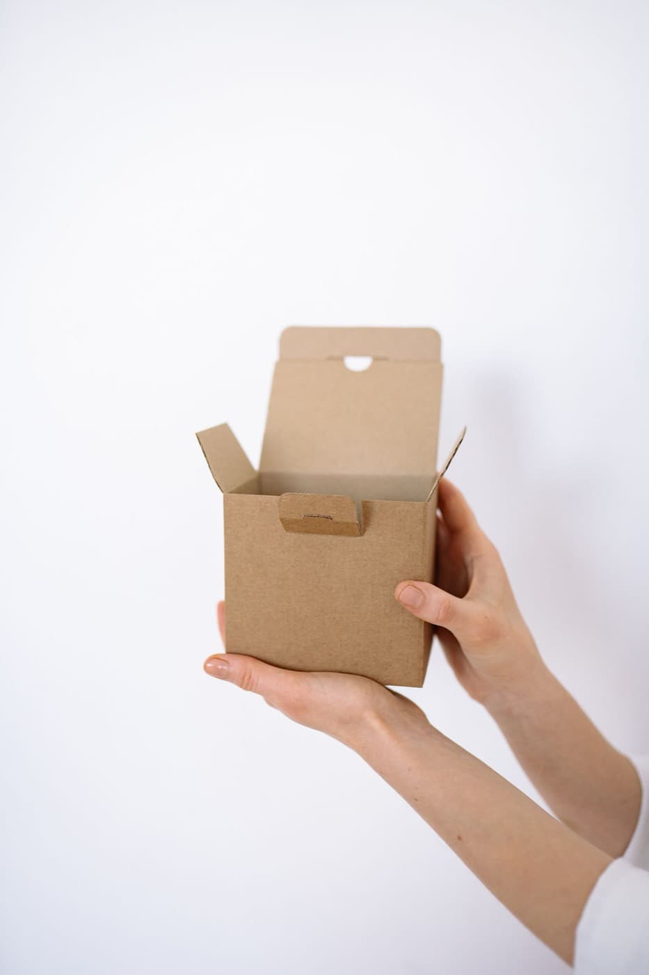 A die-cut paperboard carton structure being checked by hand